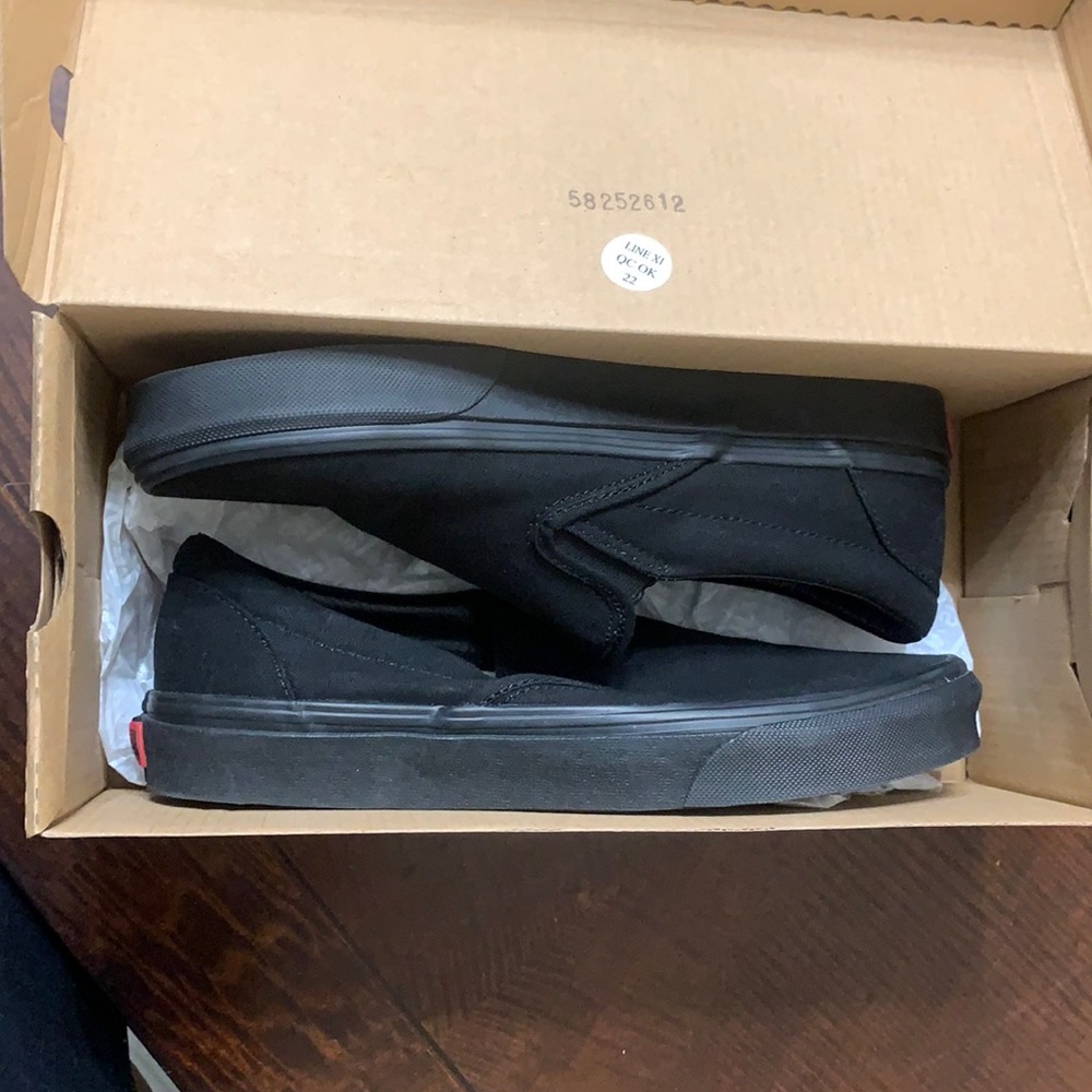 Brand new, in box, never worn black slip-on Vans. Women’s 8.5/men’s 7